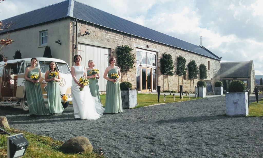 Sunny photo of bride and bridesmaids outside of Healey Barn