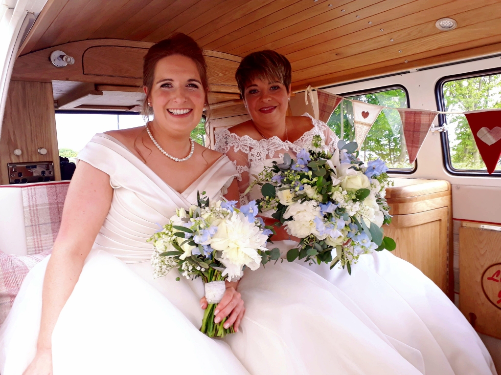 Two brides at Tynemouth in Volkswagen Campervan with blue and white flower bouquet's