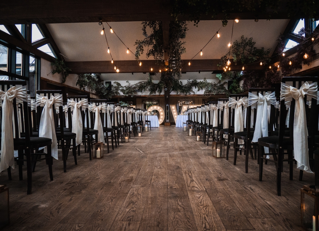 The South Causey Aisle set up for a wedding with chairs decorated and light up love sign