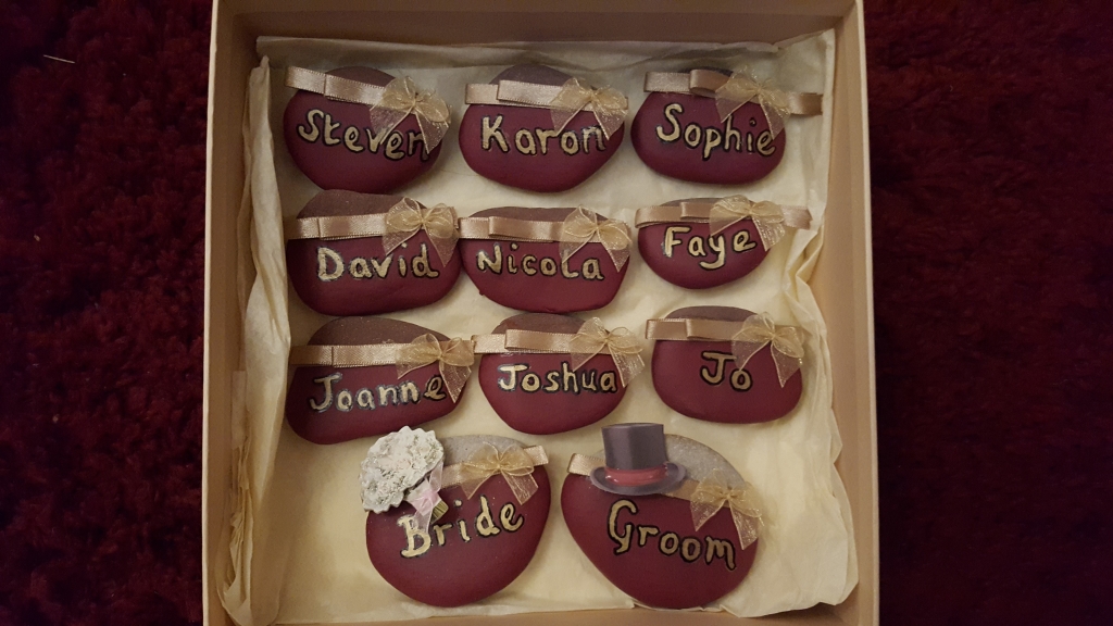 Hand made smooth pebble wedding name plates with gold painted names & ribbon detail